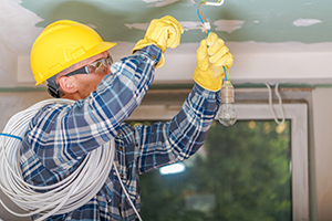 electricians fitting a light