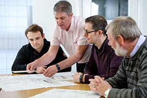 Workers learning about 18th edition on laptops