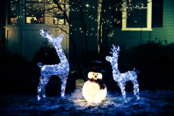 shiny Christmas decorations outside at night. reindeer family and snowman. Christmas background