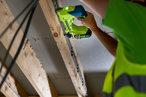 Man using the Viperclip Cable Clip Fasteing System on a wood frame