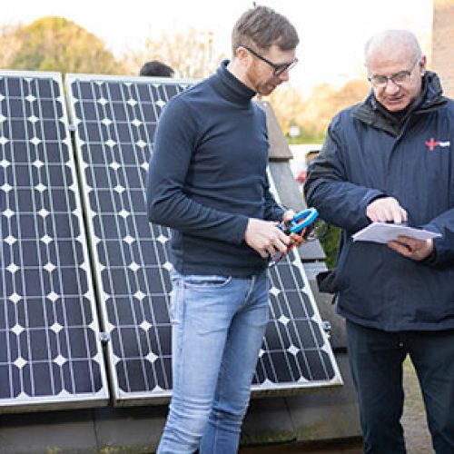 3 gentleman stood in front of solar panels - NICEIC encourages renewable solutions upskilling