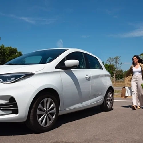 Electric Vehicle at an EV charging point lady approaching the car with bags of shopping - Top 6 Tips for Maximising Your EV's Range