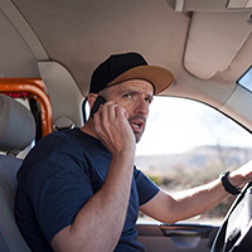 van driver on his phone conducted research from LeaseVan